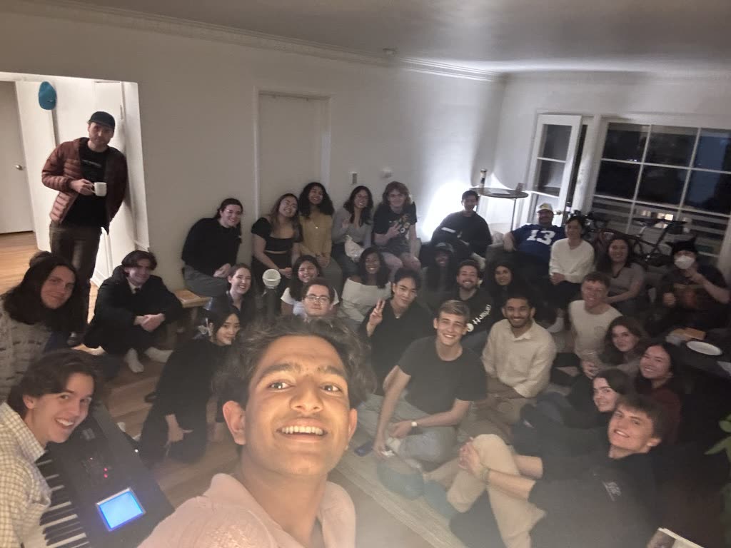 A living room packed with about thirty people at one of Ariv's open mics