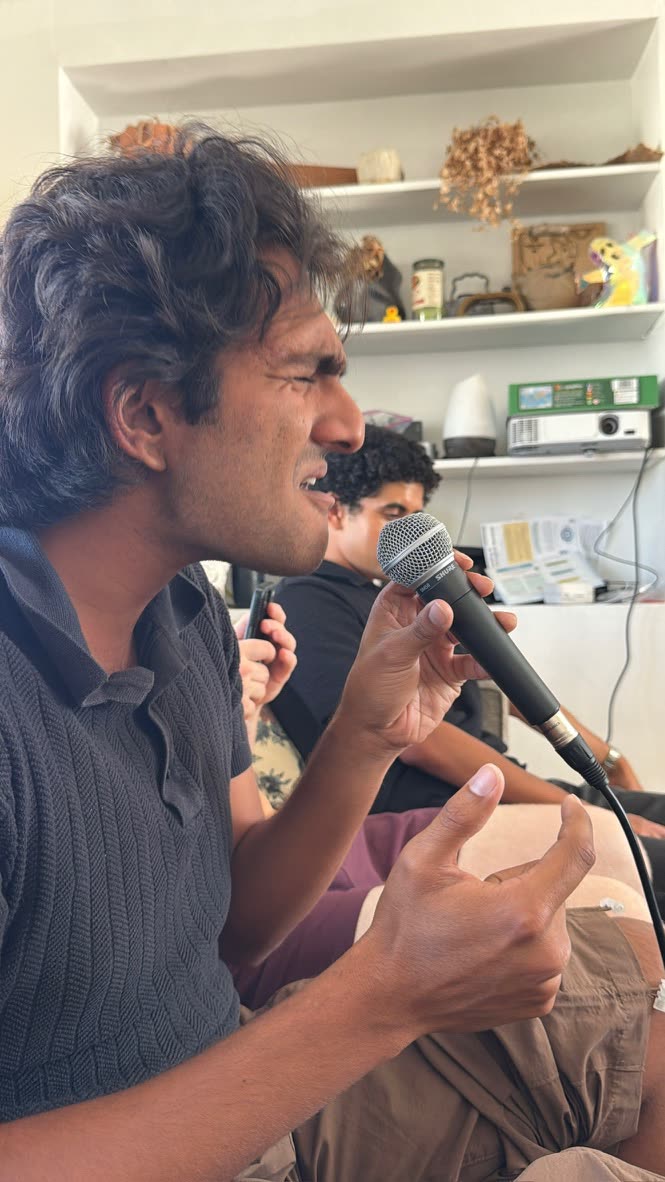 Singing into a handheld mic, eyes closed