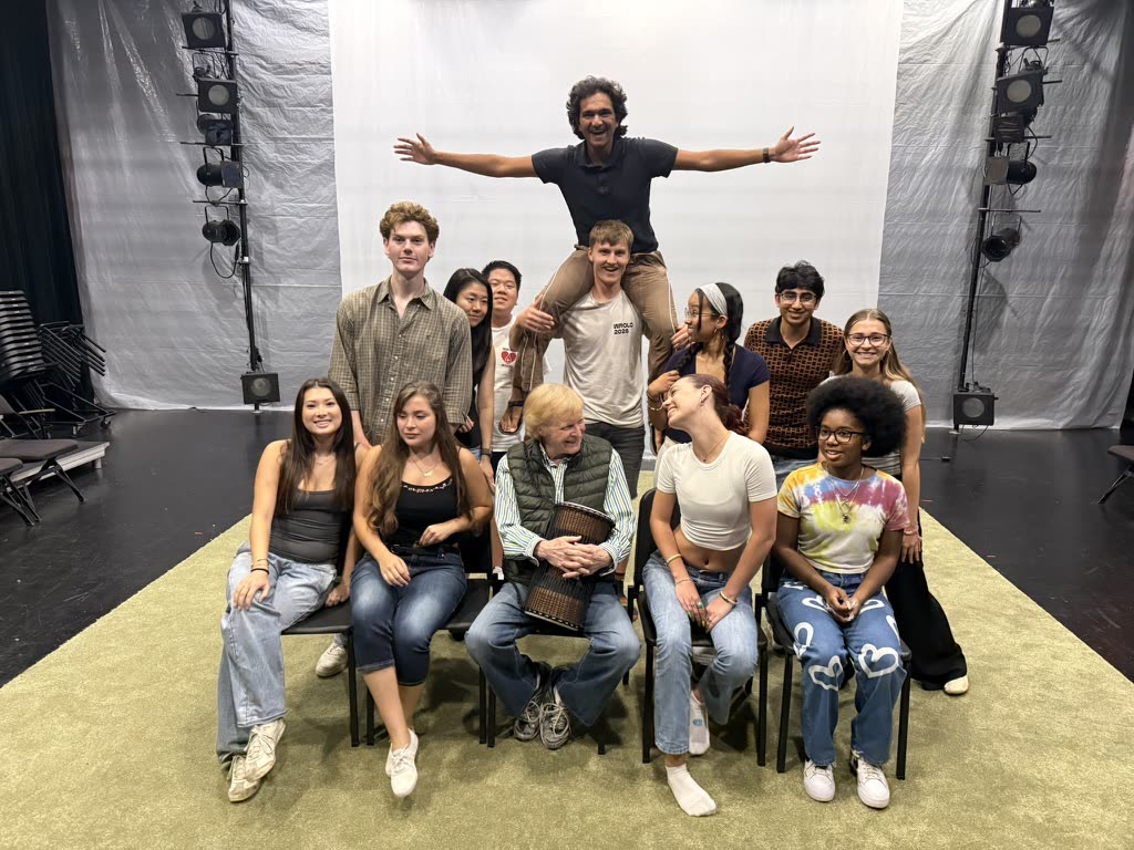 The voice class ensemble in a studio, arms wide